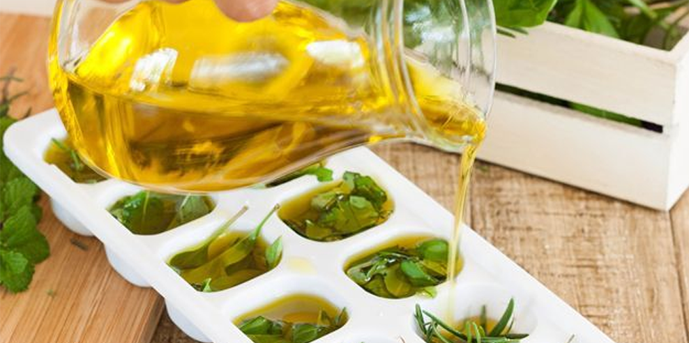 person pouring oil into an ice tray with species
